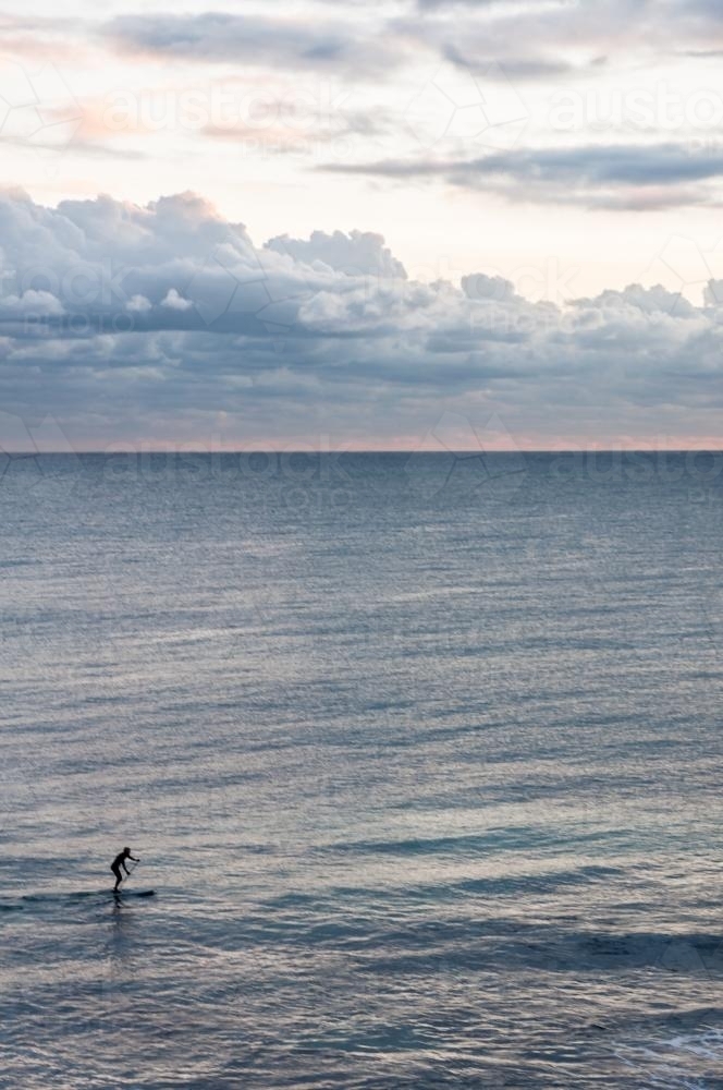 Person Riding on Stand up Paddleboard with Ocean and Horizon - Australian Stock Image