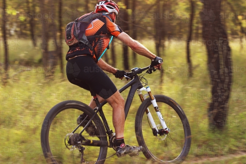 Person riding push bike on mountain bike track in the bush - Australian Stock Image