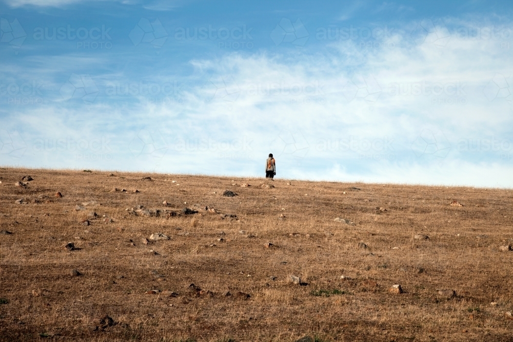 Person standing alone on a hill - Australian Stock Image