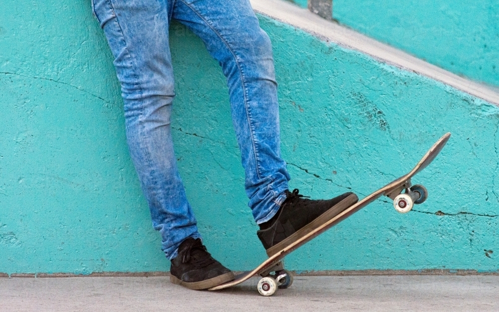 Person standing on a skateboard - Australian Stock Image