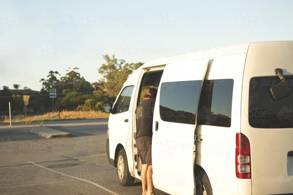 Person standing outside white van in carpark - Australian Stock Image