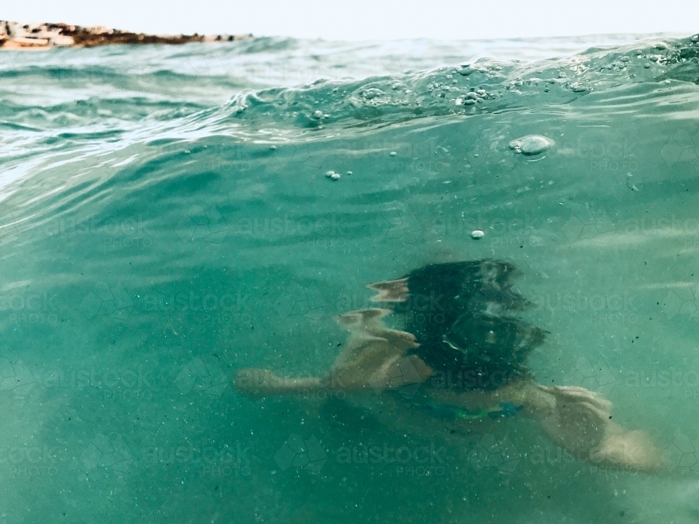 Person swimming underwater in the ocean - Australian Stock Image