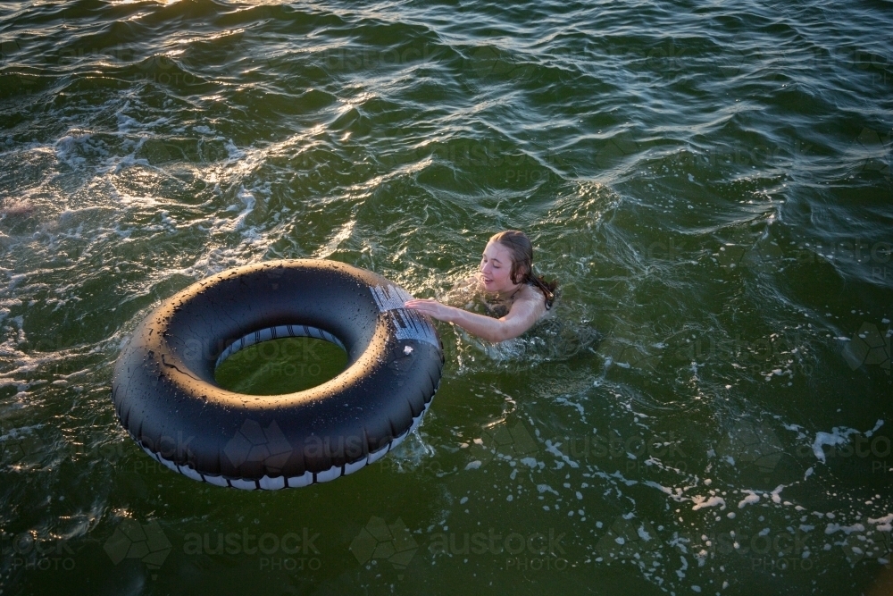 Person swimming with inflatable tube - Australian Stock Image