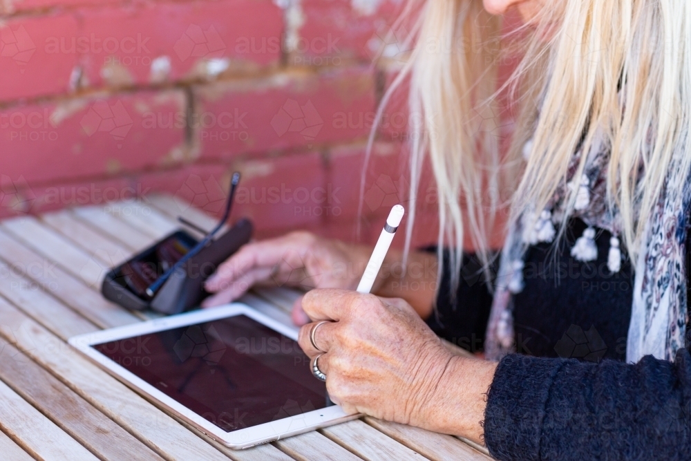 person using digital pencil to write on a tablet - Australian Stock Image