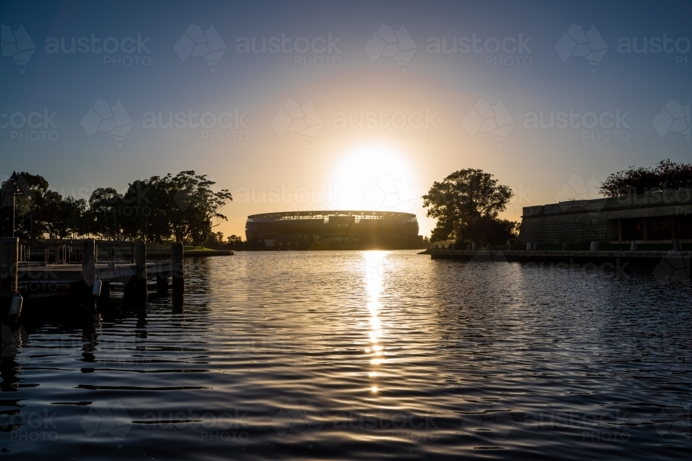 Perth AFL Stadium over water at sunset - Australian Stock Image