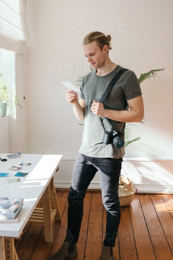 Photographer in his studio reviewing looking at a photo - Australian Stock Image