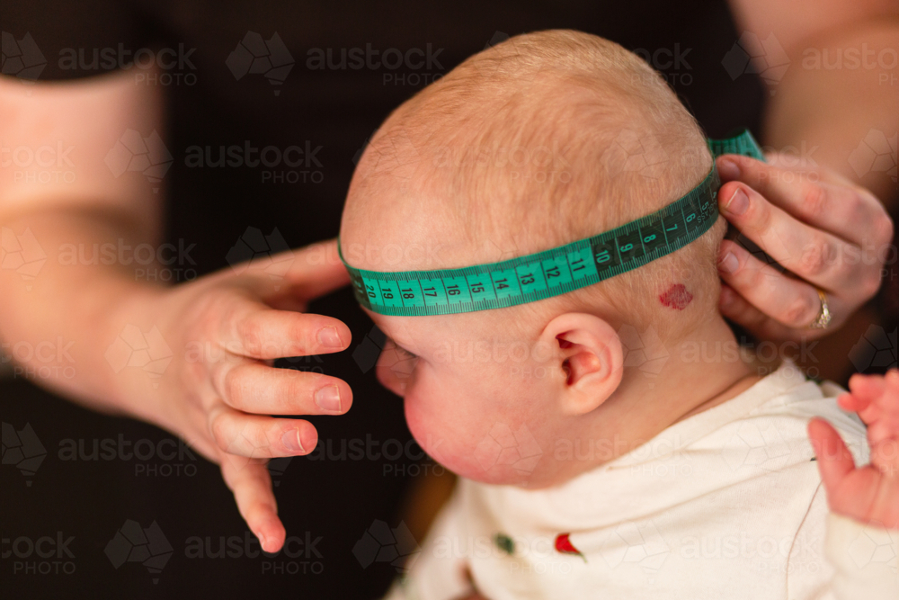 Physio performing Cranial Measurement assessment on baby - Australian Stock Image