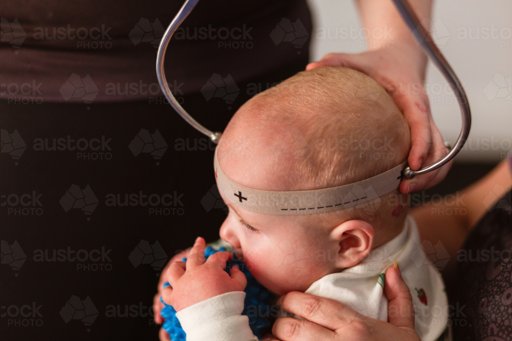 Physio performing Cranial Shape Measurement assessment Using a Caliper tool and Elastic Band - Australian Stock Image