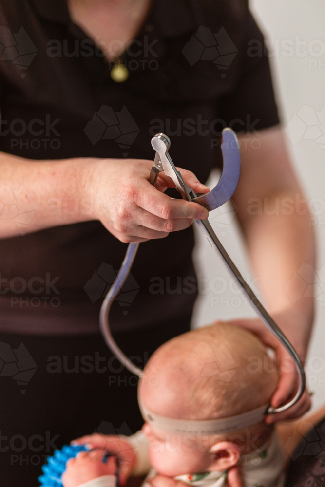 Physio performing Cranial Shape Measurement assessment Using a Caliper tool and Elastic Band - Australian Stock Image