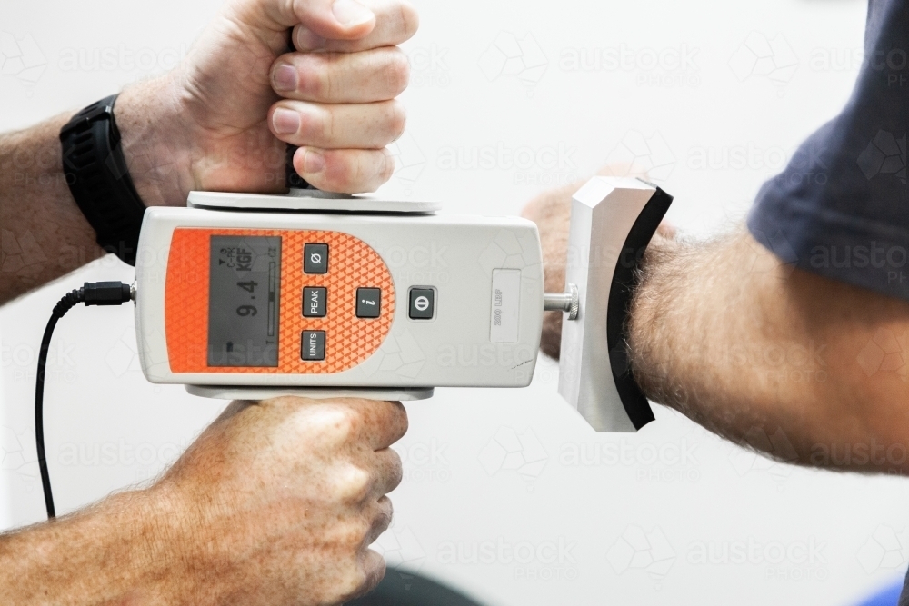 Physio using digital strength dynamometer - Australian Stock Image