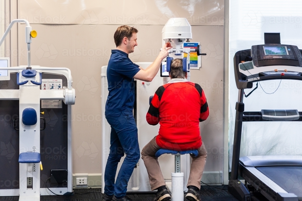 Image of physiotherapist smiling and adjusting exercise therapy ...