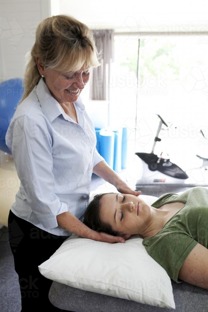 Physiotherapist treating female patient - Australian Stock Image