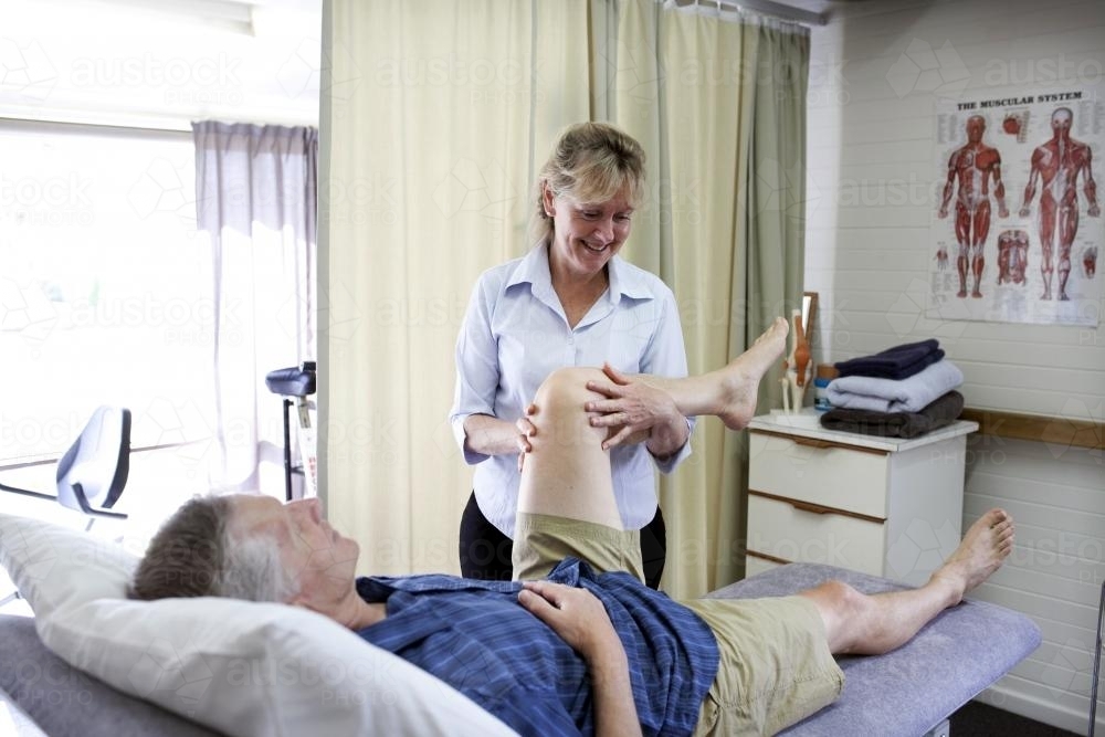 Physiotherapist treating male patient - Australian Stock Image