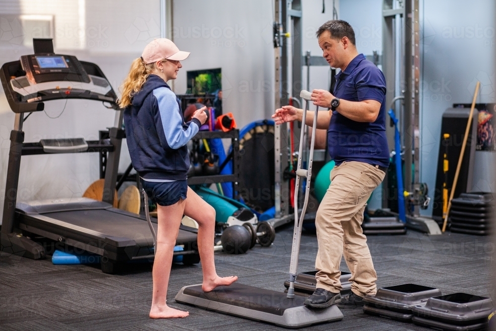 Image of Physiotherapist working with teen girl teaching her how to use