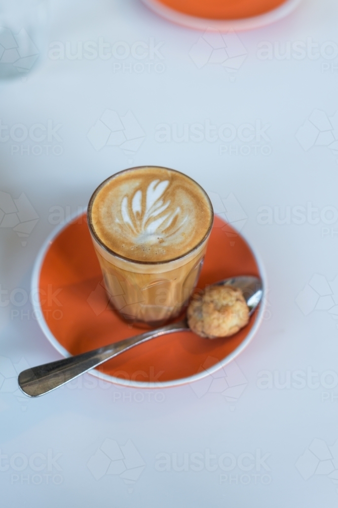 piccolo latte coffee with an orange saucer - Australian Stock Image