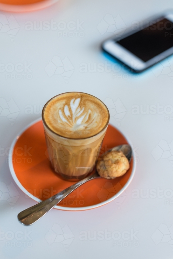piccolo latte coffee with an orange saucer - Australian Stock Image