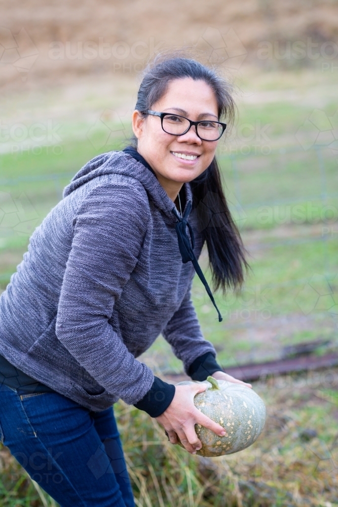 Picking a pumpkin in the garden - Australian Stock Image