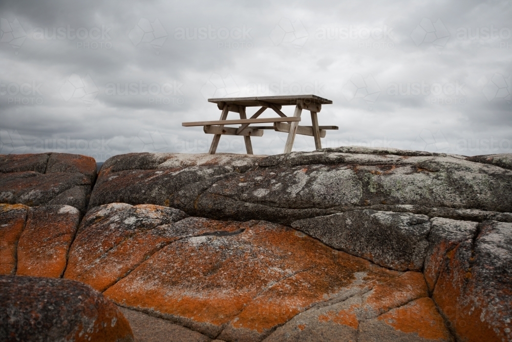 picnic table situated on lichen covered rocks - Australian Stock Image