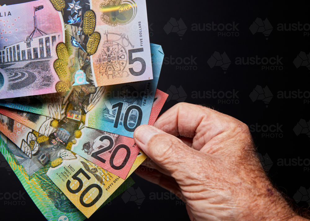 banknotes with hand on black background - Australian Stock Image