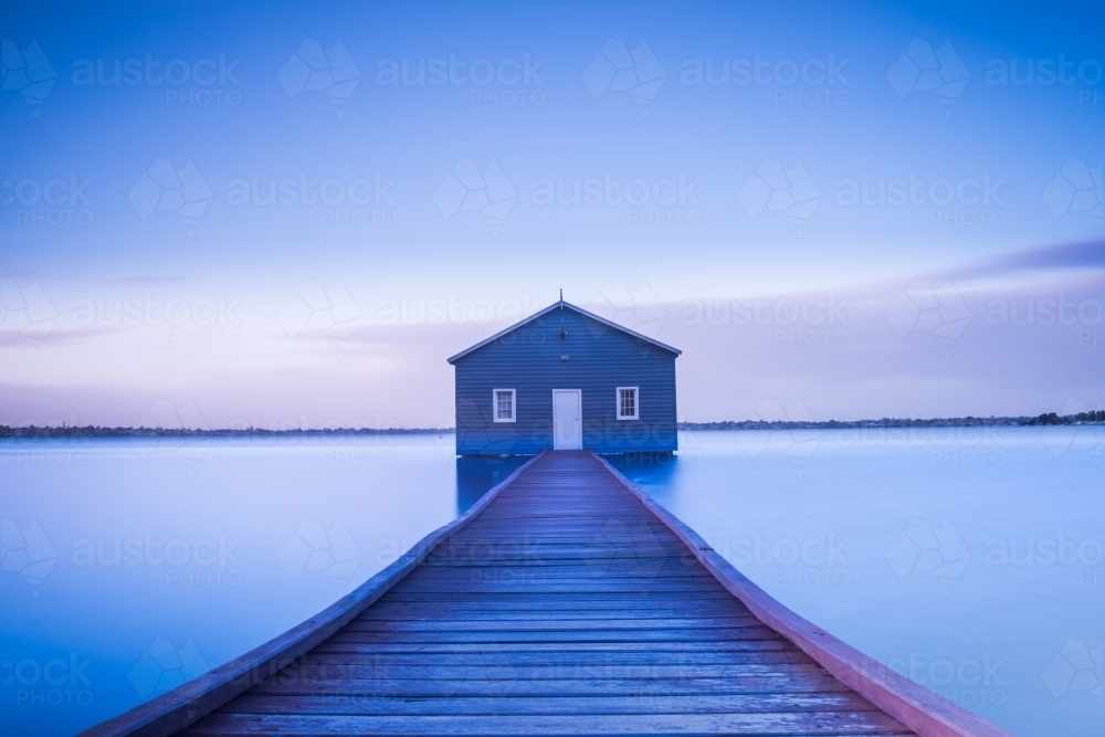Pier leading up to blue house during blue hour - Australian Stock Image