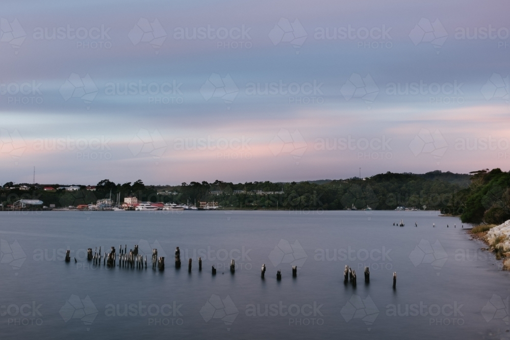 Pier Pylons at sunset in Long Bay, Strahan, Tasmania - Australian Stock Image