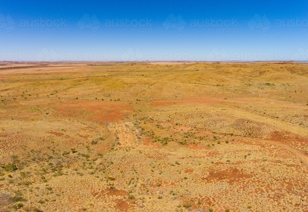 Pilbara landscape with spinifex and scrub and a blue sky - Australian Stock Image