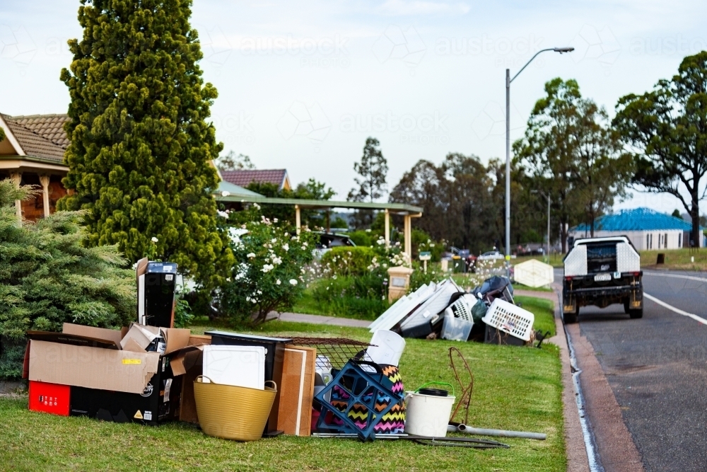 Pile of household junk on front lawn out for council bulk waste cleanup - Australian Stock Image