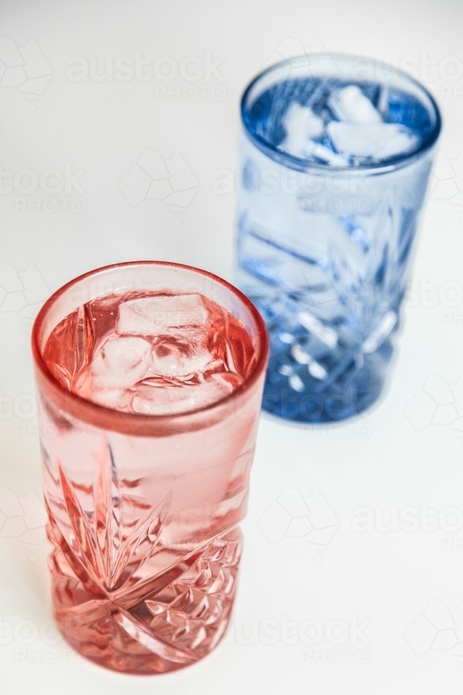 Pink and blue water glass with ice in it - cool refreshing healthy drink - Australian Stock Image