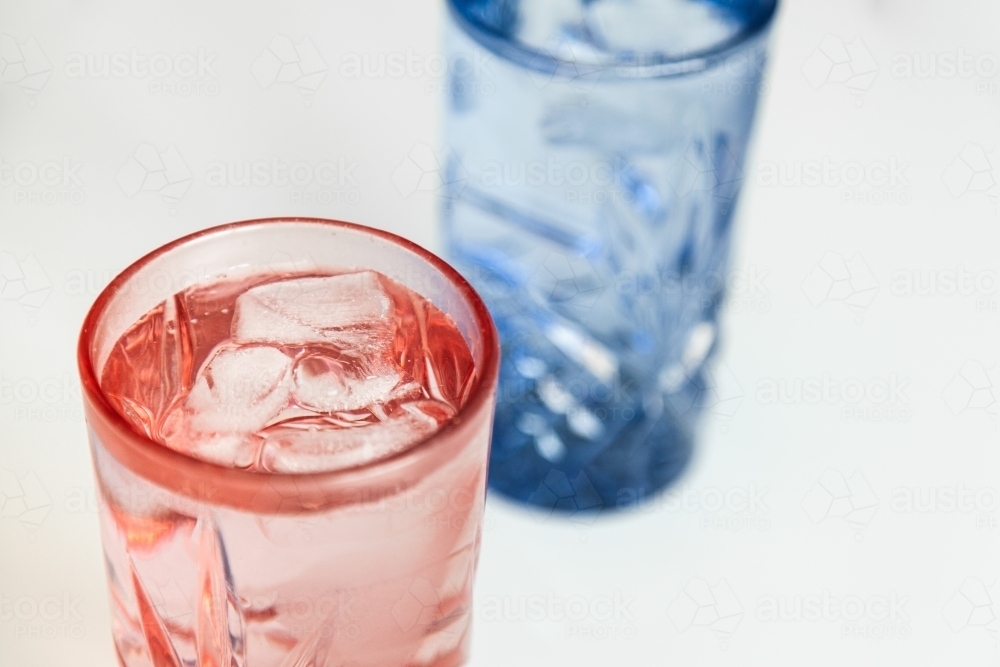Pink and blue water glass with ice in it - cool refreshing healthy drink - Australian Stock Image