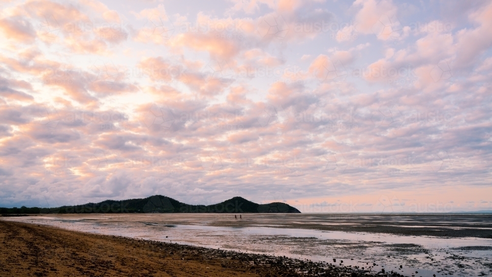Pink clouds reflected in the tidal waters. - Australian Stock Image