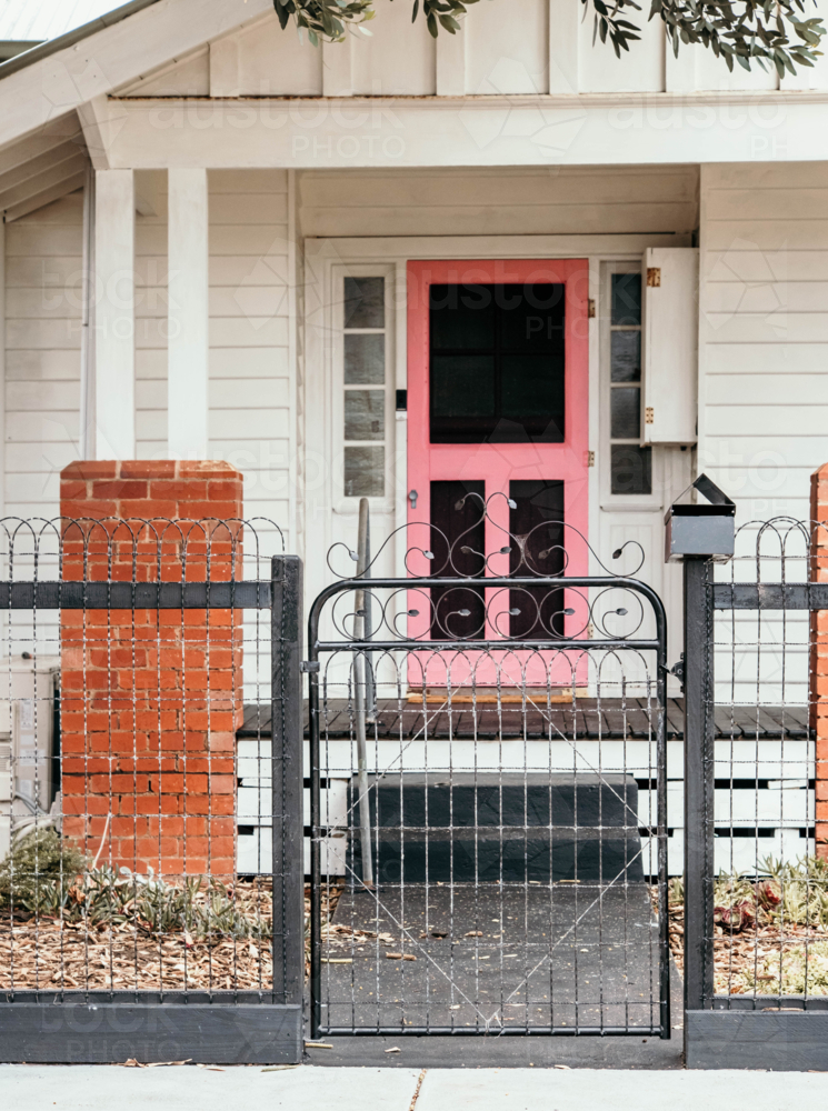 Pink entry door & iron gate on a street. - Australian Stock Image