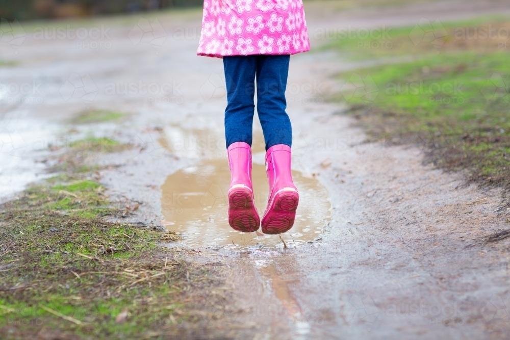 Pink gumboots, pink raincoat, wet weather - Australian Stock Image