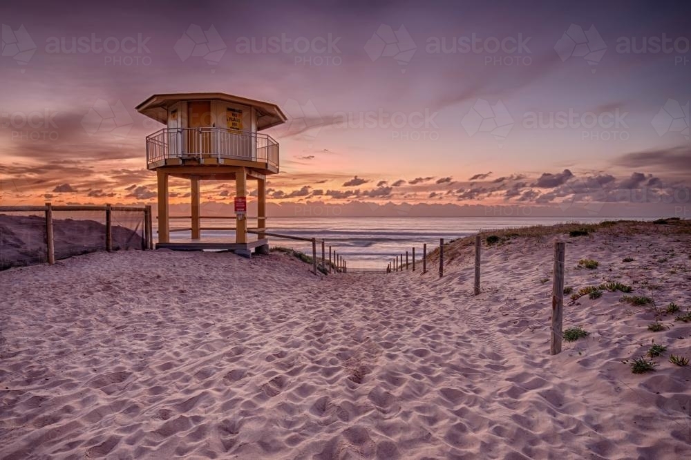 Pink Sunrise Over Ocean with Lifegaurd Tower in Foreground - Australian Stock Image