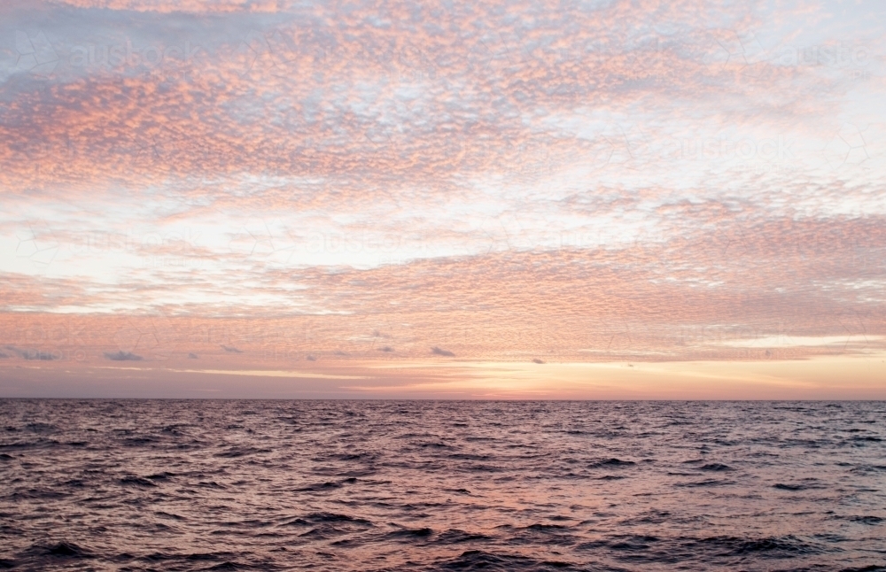 Pink Sunset over rippled ocean - Australian Stock Image