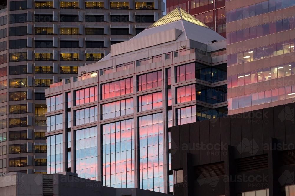 Pink sunset reflections on windows of  city buildings - Australian Stock Image