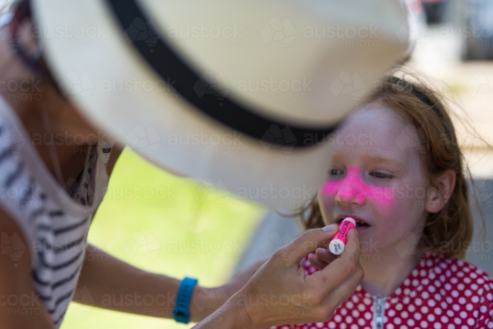 Pink zinc sunscreen being applied to a girl - Australian Stock Image