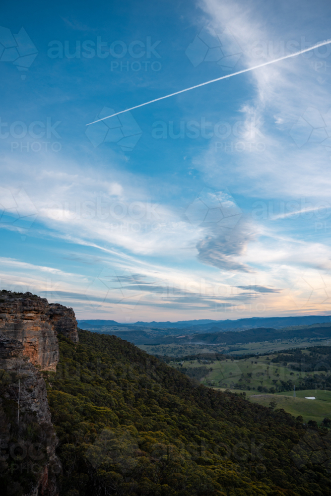 Plane trail in the sky over a cliff - Australian Stock Image