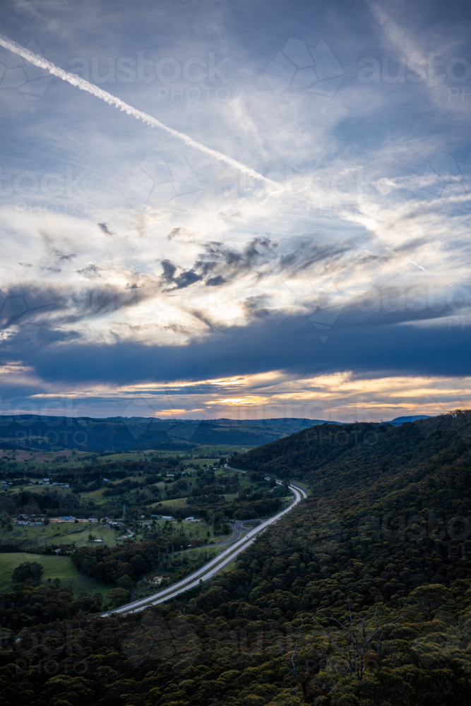 Plane trail in the sunset sky Hassan's wall, Lithgow - Australian Stock Image