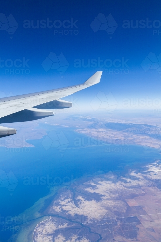 Plane wing over coastal Australian waters on long distance flight - Australian Stock Image