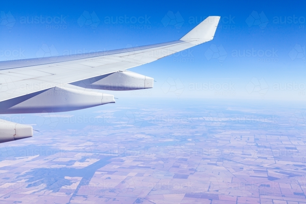 Plane wing with brown paddocks far below - Australian Stock Image