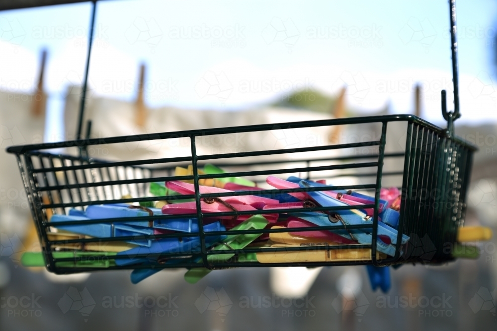 Plastic pegs in a wire basket. - Australian Stock Image
