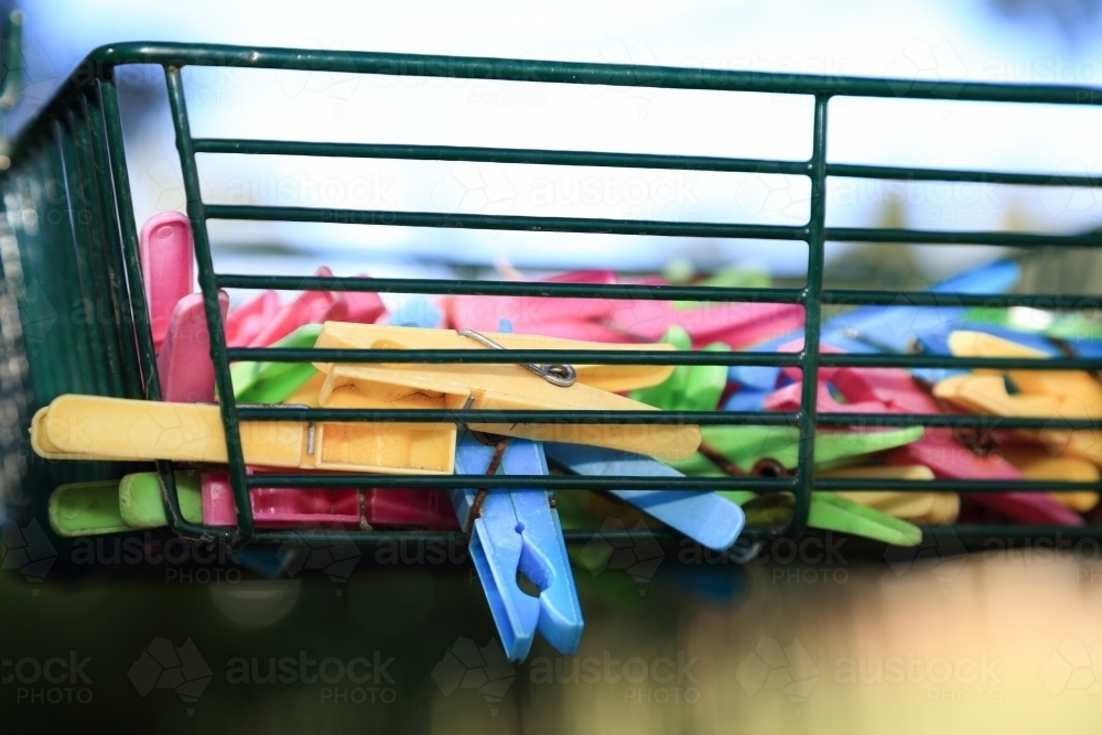 Plastic pegs in a wire basket. - Australian Stock Image