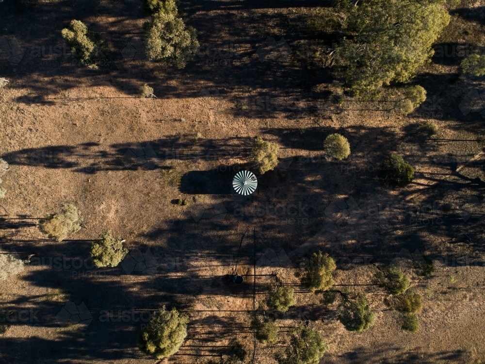 Plastic water storage tank in dry farm paddock - Australian Stock Image