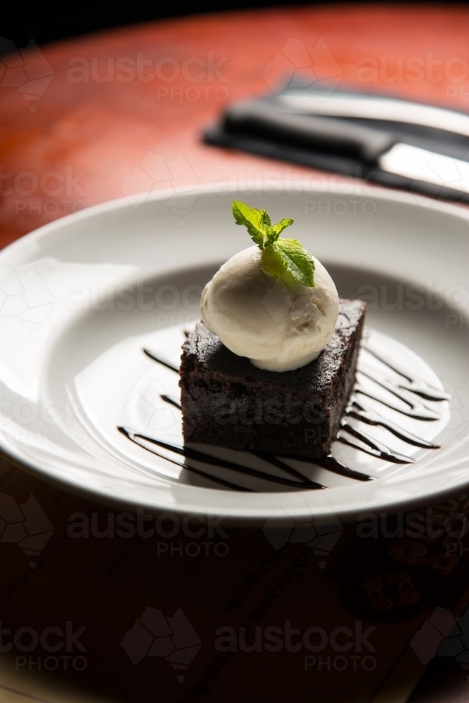 Plate of brownie and cream at a cafe - Australian Stock Image