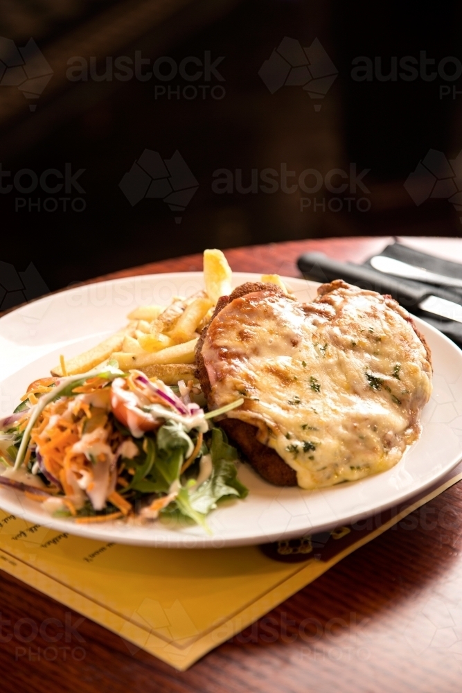 Plate of chicken parmigiana, coleslaw and chips in a cafe - Australian Stock Image