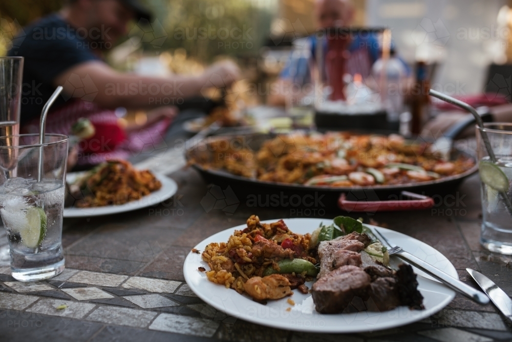 Plate of paella and food a BBQ - Australian Stock Image