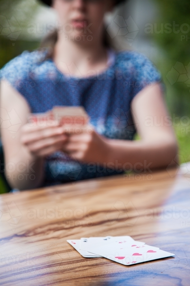Playing a card game on a table outside - Australian Stock Image