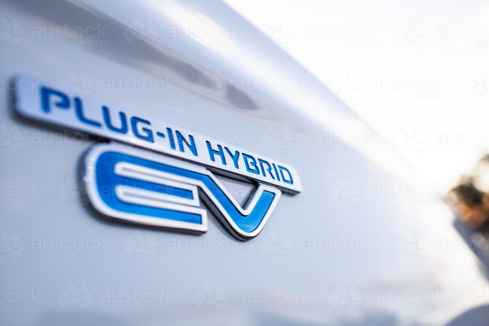 Image of Plug in hybrid EV vehicle text on side of white car - Austockphoto