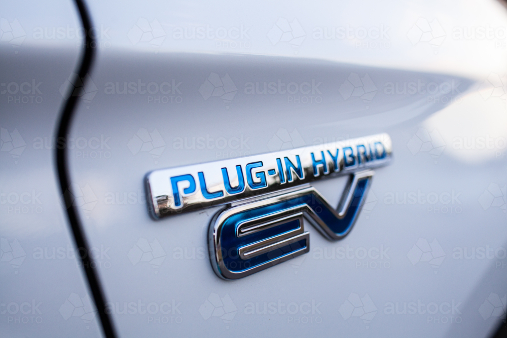 Image of Plug in hybrid EV vehicle text on side of white car - Austockphoto