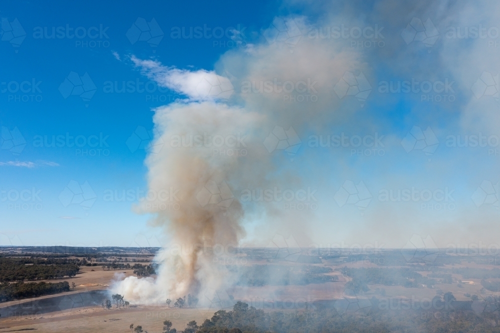 Image of plume of smoke rising from fire on rural farming property ...